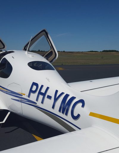 Cirrus SR20 from the side with doors open and flaps down PH-YMC